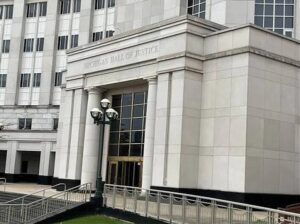 mi sup ct - NARSOL Front entrance of the Michigan Hall of Justice, a stone government building with tall columns, gold doors, and a ramp.